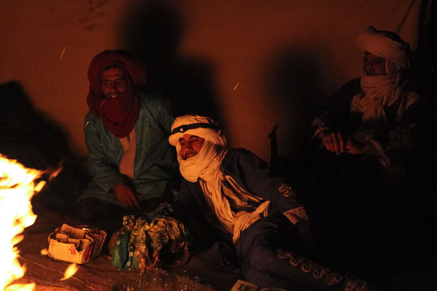 Men sitting around a fire in the desert at night